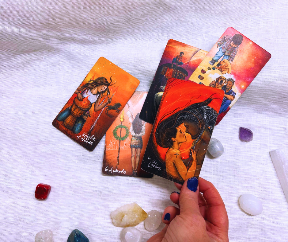 photo of a selection of tarot cards with a woman holding the lovers tarot card